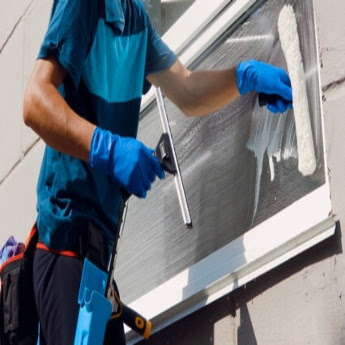 A The Exterior Group Technician cleaning the windows of a business.