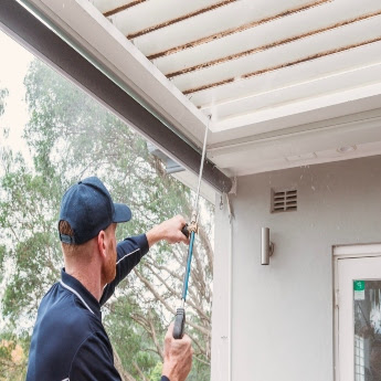 The Exterior Group technician using a professional-grade pressure washer. 