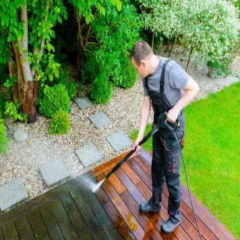 A The Exterior Group technician using special detergents and oxidizers in his pressure. washing mix.