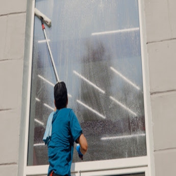 A The Exterior Group professional technician using a squeegee to clean windows. 