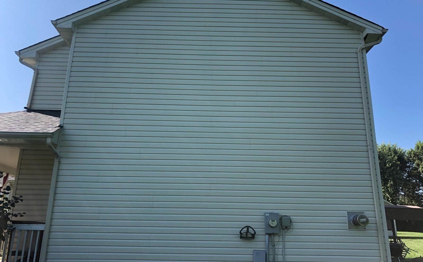 Newly washed siding on a white, two-story house.